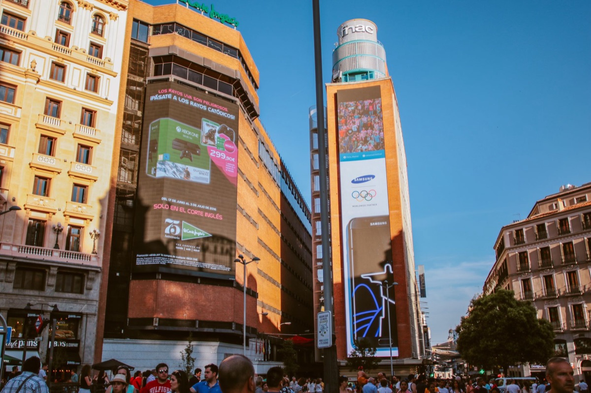 Membros BTS ao lado de uma placa publicitária gigante