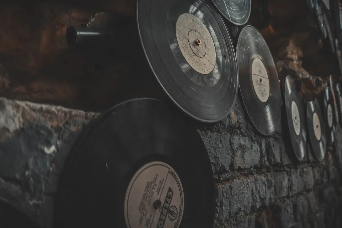 Close-up of vintage vinyl records displayed on a rustic brick wall, creating an artistic, nostalgic atmosphere.